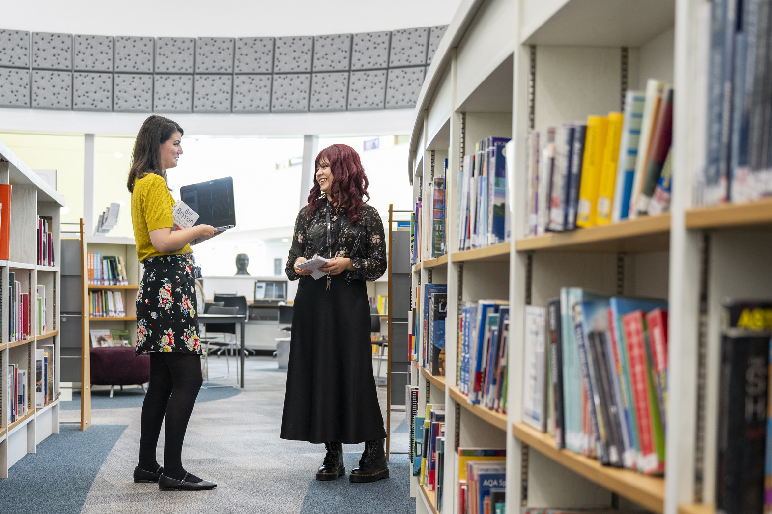 Two staff members talking in the library