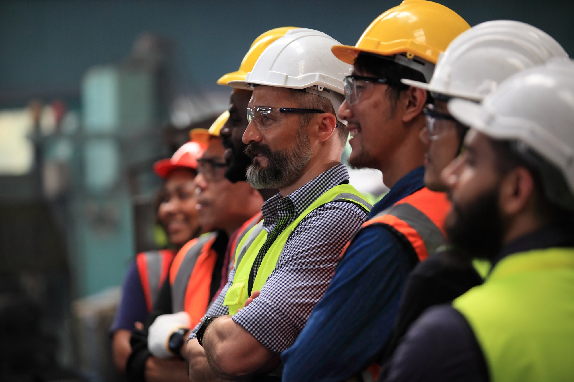 Several people in hard hats and hi-vi vests, demonstrating the group's training and work placements provision for employers.