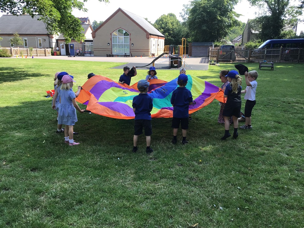 Exning Primary School pupils playing with a colourful giant sheet