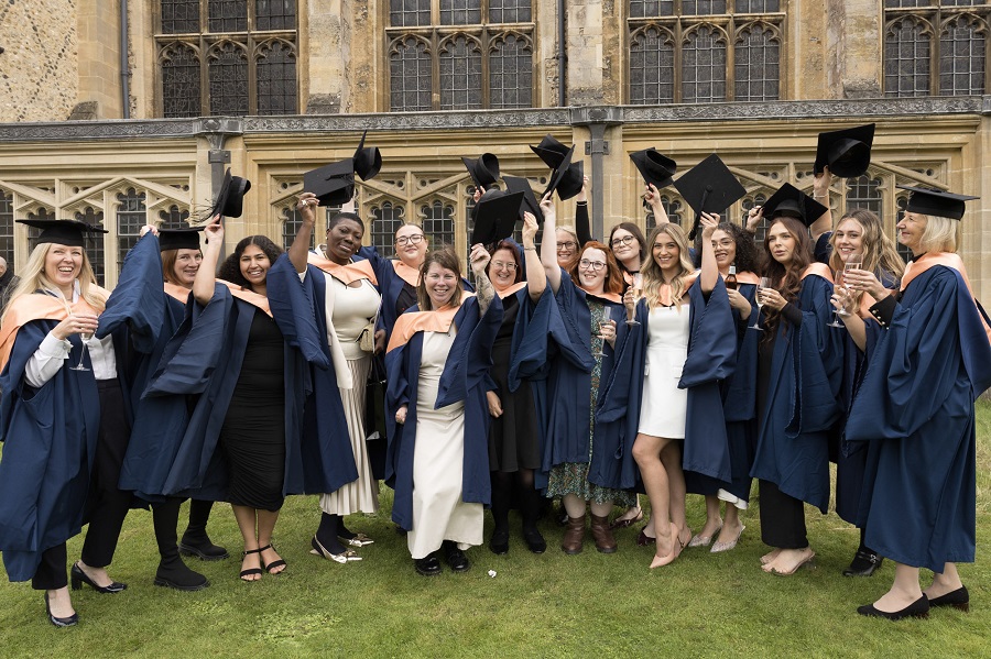 Graduates raising their hats at Graduation 2024