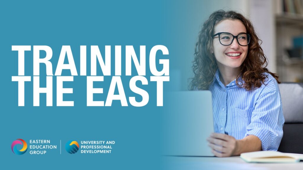 Smiling woman sitting at a desktop with a laptop. Training The East text is overlaid.