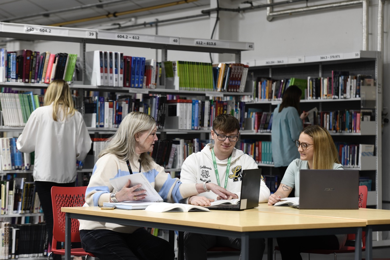 Students sat at a laptop in the library