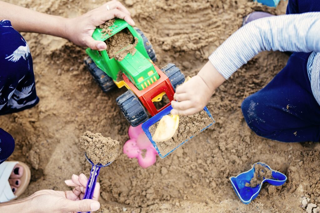 Boy playing with mother in sandbox